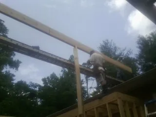 Carpenter setting a ridge beam over a new addition frame — Ice Dam Removal by Roofing Brothers in Kahlotus